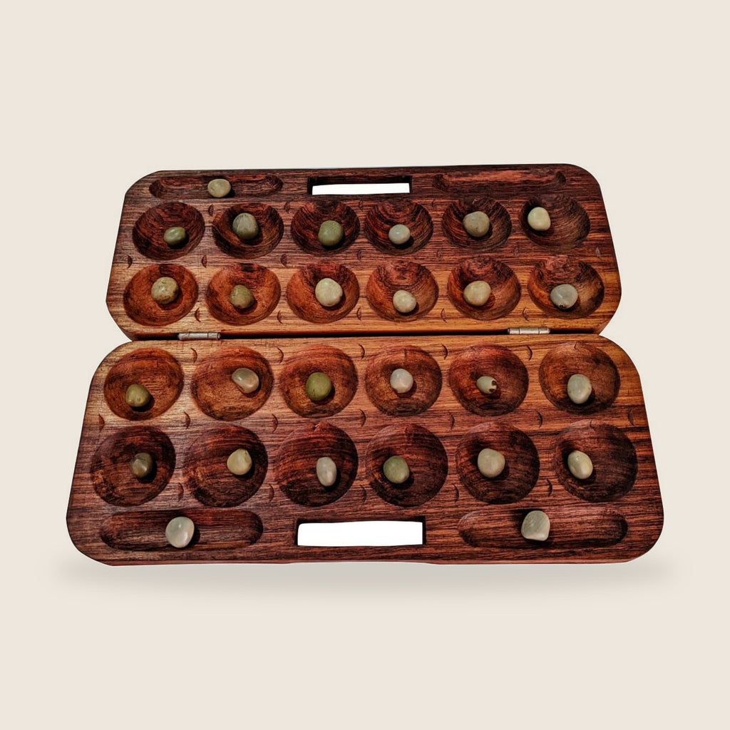 Katro Traditional Malagasy Game | Gasy Karts – 6-hole Katro board with seeds in play